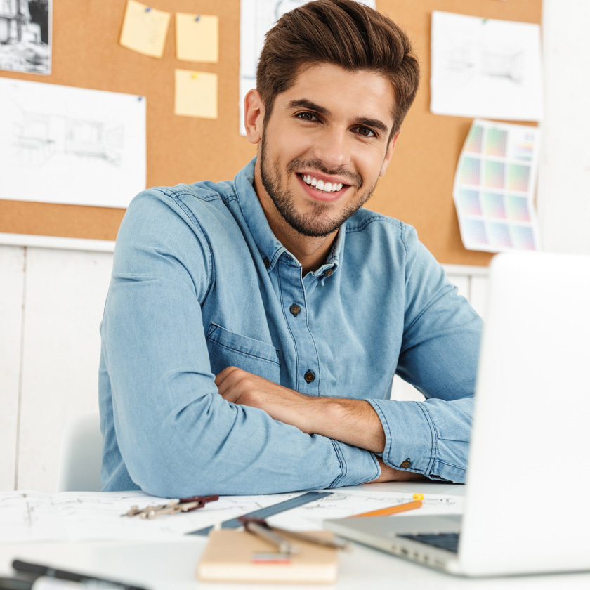 young-white-man-smiling-while-working-with-laptop-2026-01-08-05-30-41-utc